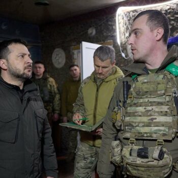 Le président ukrainien Volodymyr Zelensky (g) lors d'une visite à une brigade sur la ligne de front dans la région de Koupiansk, le 19 février 2024
