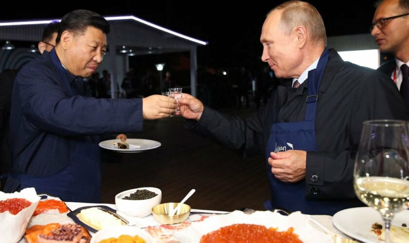Le président russe Vladimir Poutine porte un toast avec son homologue chinois Xi Jinping alors qu'ils dégustent les blinis au caviar qu'ils ont cuisinés, en marge du Forum économique de l'Est à Vladivostok le 11 septembre 2018.