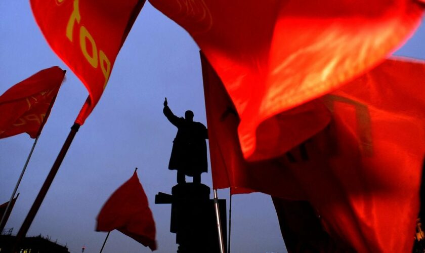 Red flags of Russian Communists fly near a monument to the Soviet Union founder Vladimir Lenin during a rally to mark the 90th anniversary of his death in St.Petersburg, late on January  21, 2014. AFP PHOTO / OLGA MALTSEVA (Photo by OLGA MALTSEVA / AFP)