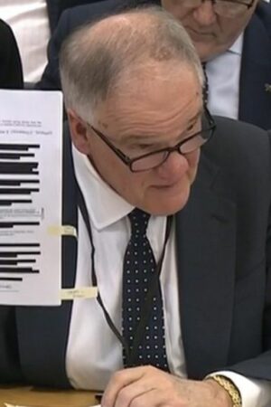 Henry Staunton holding up redacted document