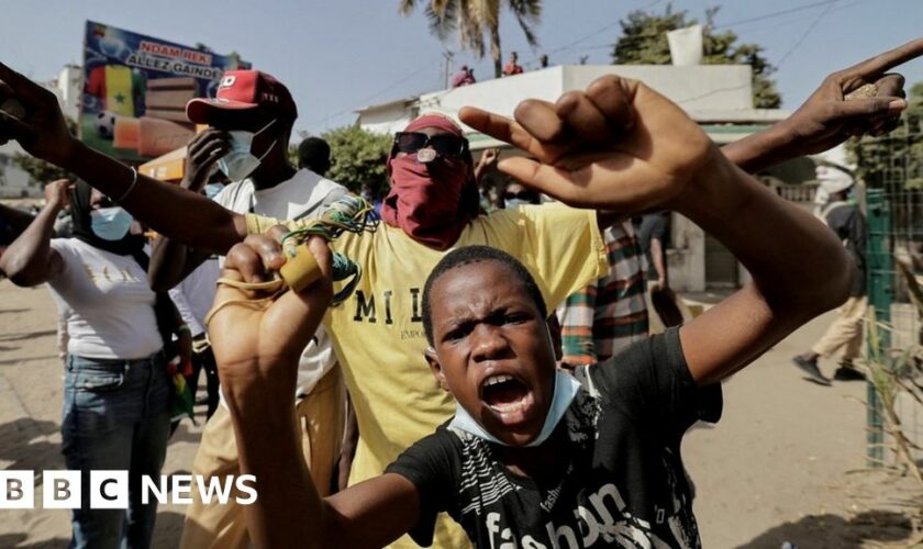 Protesters stand in front of burning barricades in Dakar, Senegal