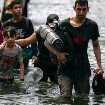 Des migrants traverent la rivière Tuquesa près de Bajo Chiquito, après avoir traversé à pied la jungle du Darien, le 22 septembre 2023 à la frontière entre le Panama et la Colombie
