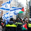 Demonstrators hold Palestinian and Israeli flags. Pic: Reuters/Piroschka van de Wouw