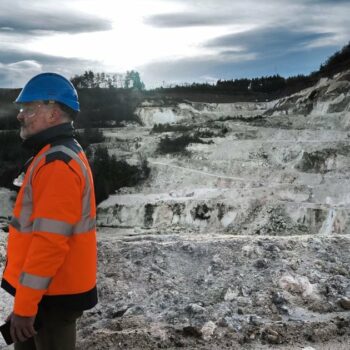 An employee walk in the open-pit mine at the lithium plant of French multinational industrial minerals company Imerys in Echassierres, central France, on January 17, 2024. Minerals group Imerys has undertaken the Emili project, aimed at extracting lithium at its Beauvoir site to help Europe limit its dependence on China. Scientists consider the Massif Central's lithium potential to be "more than respectable", but mining projects are a source of both economic hope and environmental concern. (Photo by OLIVIER CHASSIGNOLE / AFP)