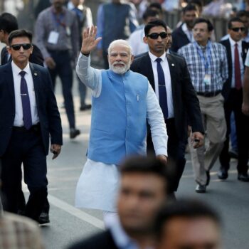 FILE PHOTO: India's Prime Minister Narendra Modi waves to his supporters as he arrives to cast his vote during the second and last phase of Gujarat state assembly elections in Ahmedabad, India, December 5, 2022. REUTERS/Amit Dave/File Photo