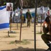 Un soldat israélien se recueille devant des photos de personnes capturées ou tuées par des militants du Hamas lors du festival de musique Supernova le 7 octobre, sur le site où l'attaque meurtrière a eu lieu, près du kibboutz Reim, dans le sud d'Israël, le 5 janvier 2024