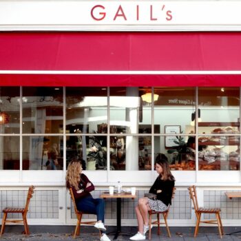 Customers observe social distancing as they sit outside a branch of Gail's bakery on Upper Street in Islington, North London.