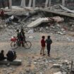 Des Palestiniens observent les gravats d'un bâtiment le 29 mars 2024 après une frappe israélienne nocturne à Rafah, dans le sud de la bande de Gaza, où une guerre oppose Israël au mouvement islamiste Hamas