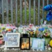 Floral tributes with candles and football t-shirts, balloons etc tied to railings