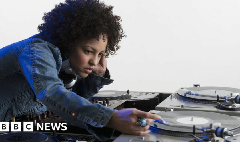 Stock image of a woman DJ-ing at a set of record decks