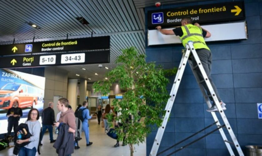 Ein Arbeiter ändert Schilder am Flughafen von Bukarest