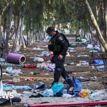 An Israeli security officer inspects the scene of the 7 October attack by Hamas gunmen on the Nova music festival in Reim, Israel (17 October 2023)
