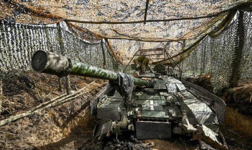 Un char de la 1ère brigade de chars des forces terrestres ukrainiennes, dissimulé par des filets de camouflage, le 31 mars 2024
