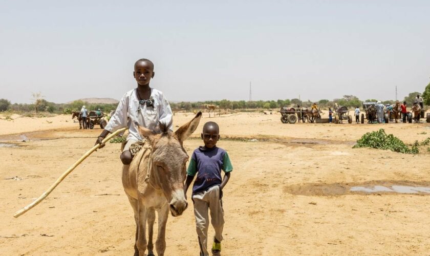 Deux jeunes traversent la frontière entre le Tchad et le Soudan dans le camp de réfugiés de Koufroun, le 9 avril 2024