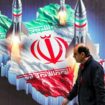 Un homme marche devant la carte de l'Iran dans le centre de Téhéran, le 15 avril 2024
