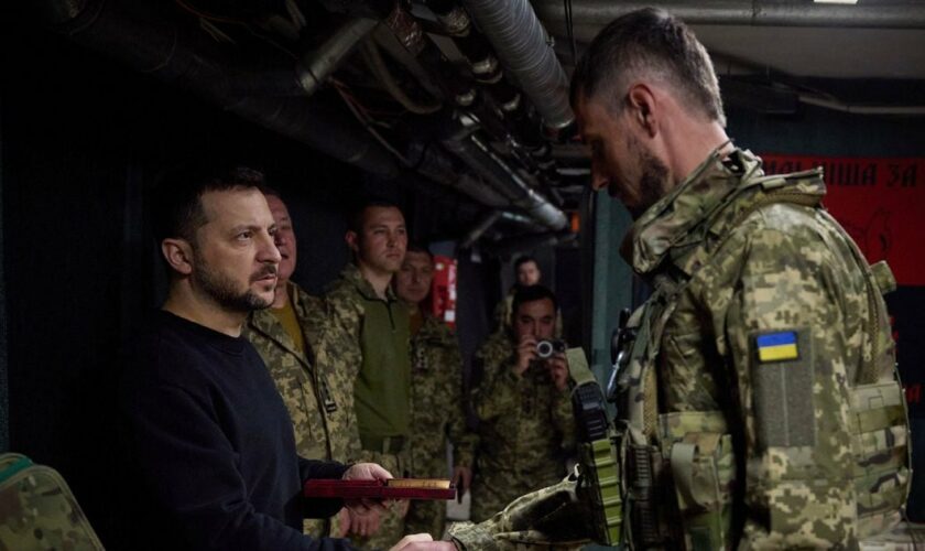 Le président ukrainien Volodymyr Zelensky (g) récompense un militaire ukrainien sur la ligne de front dans la région de Donetsk, le 19 avril 2024