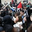 Des contre-manifestants, tenant des pancartes du collectif "Nous Vivrons" en soutien à Israël font face à des manifestants en soutien aux Palestiniens manifestant à l'entrée de Sciences Po Paris occupé par des étudiants, à Paris le 26 avril 2024.