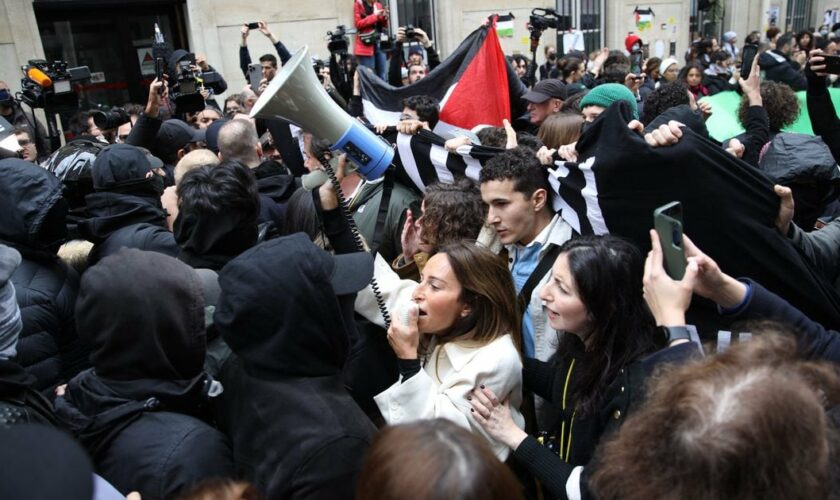 Des contre-manifestants, tenant des pancartes du collectif "Nous Vivrons" en soutien à Israël font face à des manifestants en soutien aux Palestiniens manifestant à l'entrée de Sciences Po Paris occupé par des étudiants, à Paris le 26 avril 2024.