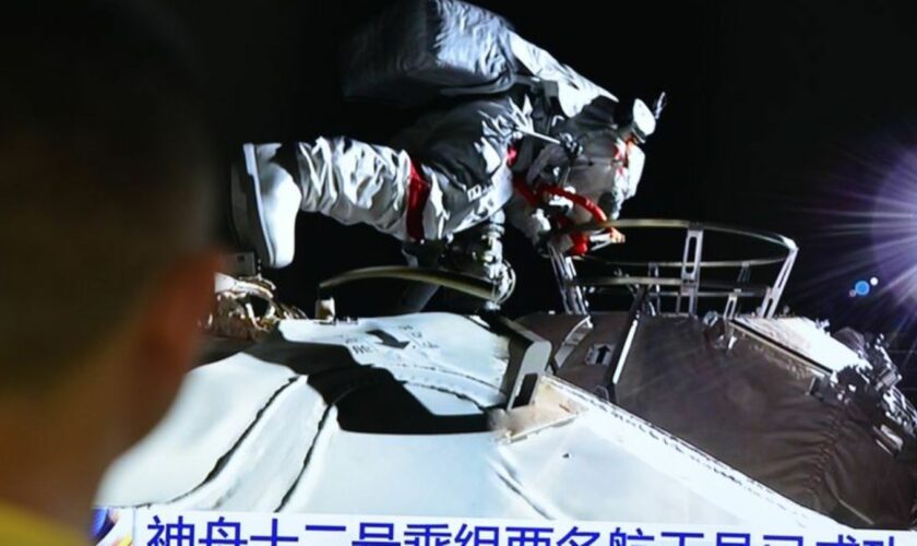 Ein Mann verfolgt vor dem Fernseher die Live-Übertragung eines Außeneinsatzes an der Raumstation "Tiangong" (Archivbild). Foto: