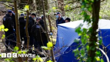 Police officers by a forensic tent at Kersal Dale, near Salford