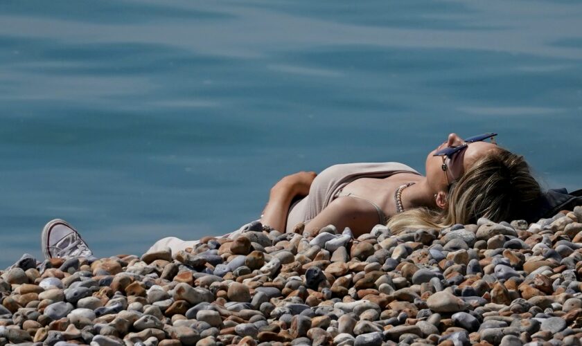 A lady enjoys the warm weather on the beach in Hastings, East Sussex. Picture date: Thursday May 9, 2024.