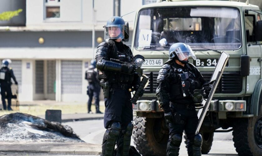 Des gendarmes français gardent l'entrée du quartier de la Vallée-du-Tir, à Nouméa, le 14 mai 2024, au milieu de manifestations liées au débat sur un projet de loi constitutionnelle visant à élargir le corps électoral pour les prochaines élections du territoire français d'outre-mer de Nouvelle-Calédonie.