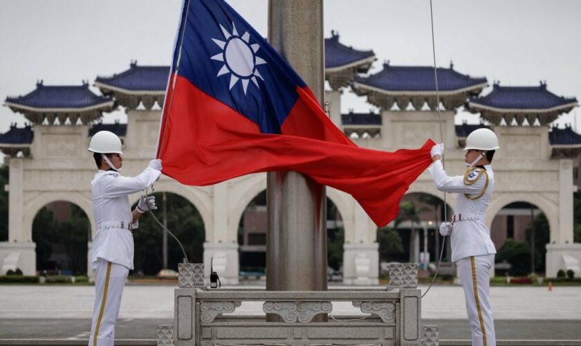 Des gardes d'honneur hissent le drapeau taïwanais sur le boulevard de la démocratie, au mémorial de Chiang Kai-shek à Taipei, le 23 mai 2024. (Photo de Yasuyoshi CHIBA / AFP)