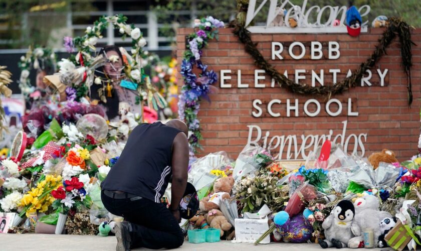 FILE - Reggie Daniels pays his respects a memorial at Robb Elementary School, Thursday, June 9, 2022, in Uvalde, Texas. The 19 fourth-graders and two teachers killed at the elementary school  are being remembered, Friday, May 24, 2024 as the second anniversary of the one of the deadliest school shootings in U.S. history is marked.  (AP Photo/Eric Gay)