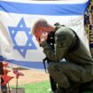 Un soldat israélien se recueille devant des photos de personnes capturées ou tuées par des militants du Hamas lors du festival de musique Supernova le 7 octobre, sur le site où l'attaque meurtrière a eu lieu, près du kibboutz Reim, dans le sud d'Israël,
