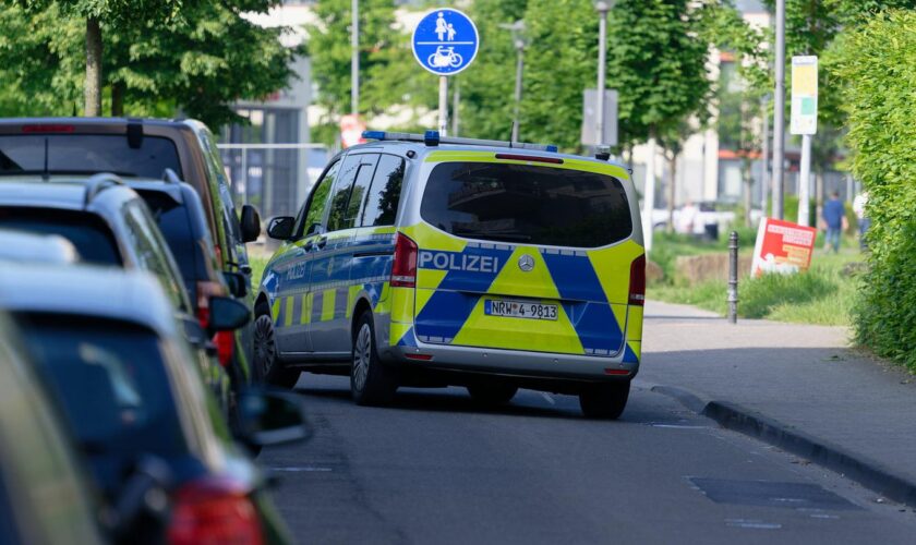 Ein Polizeiauto steht in einer Straße am Rand des Bürgerparks in Köln-Kalk