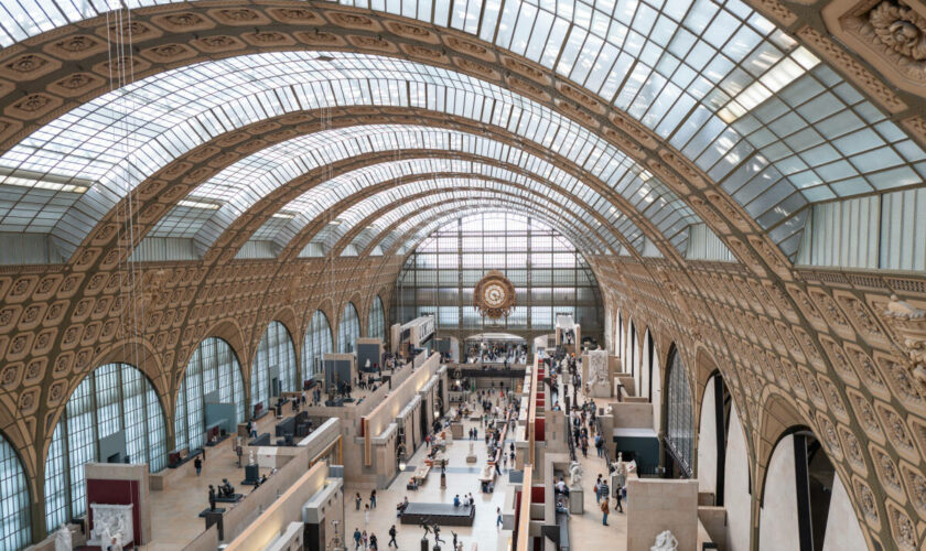 Une militante de Riposte alimentaire colle un poster adhésif sur un tableau de Monet au Musée d’Orsay