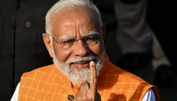Le premier ministre indien Narendra Modi montre son doigt marqué d'encre, preuve qu'il a voté aux élections législatives, le 7 mai 2024, à Ahmedabad (Inde).