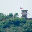 North Korean soldiers stand near their military guard post as a North Korean flag flutters in the wind, seen from Paju, South Korea, Sunday, June 9, 2024. South Korean soldiers fired warning shots after North Korean troops briefly violated the tense border earlier this week, South Korea's military said Tuesday, as the rivals are embroiled in Cold War-style campaigns like balloon launches and propaganda broadcasts. (AP Photo/Lee Jin-man)