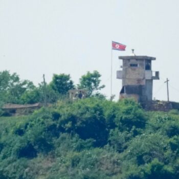 North Korean soldiers stand near their military guard post as a North Korean flag flutters in the wind, seen from Paju, South Korea, Sunday, June 9, 2024. South Korean soldiers fired warning shots after North Korean troops briefly violated the tense border earlier this week, South Korea's military said Tuesday, as the rivals are embroiled in Cold War-style campaigns like balloon launches and propaganda broadcasts. (AP Photo/Lee Jin-man)