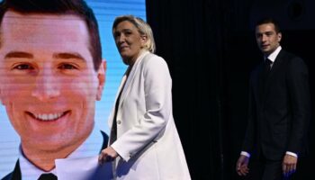 Marine Le Pen (gauche) et le président du Rassemblement national Jordan Bardella arrivent sur scène devant les militants de leur parti, le 9 juin 2024 à Paris