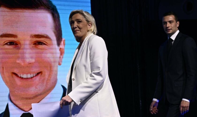 Marine Le Pen (gauche) et le président du Rassemblement national Jordan Bardella arrivent sur scène devant les militants de leur parti, le 9 juin 2024 à Paris