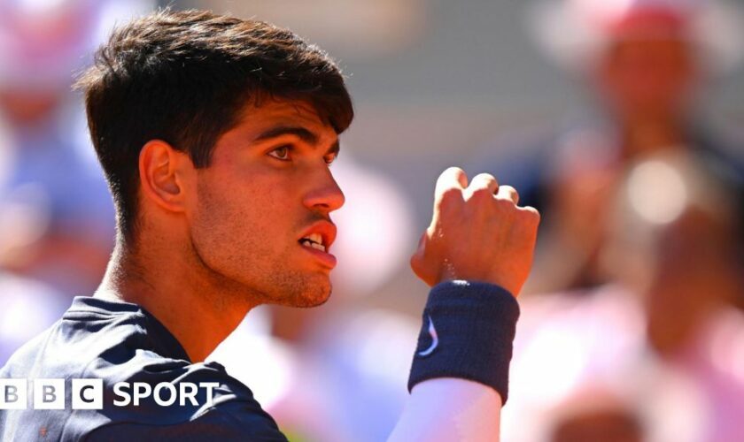 Carlos Alcaraz clenches his fist and his teeth in celebration at the French Open