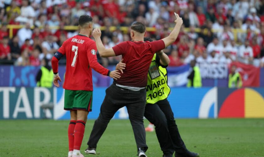 Ein Flitzer, der ein Selfie mit Cristiano Ronaldo gemacht hat, wird von einem Ordner weggezogen