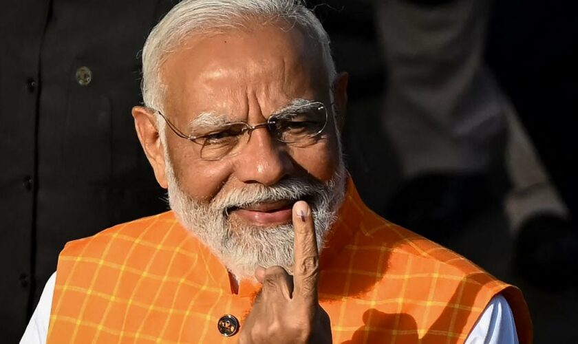 Le premier ministre indien Narendra Modi montre son doigt marqué d'encre, preuve qu'il a voté aux élections législatives, le 7 mai 2024, à Ahmedabad (Inde).