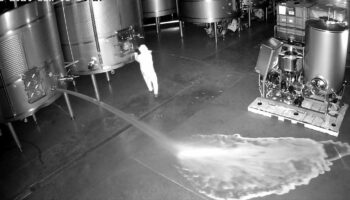 Eine Überwachungskamera-Aufnahme zeigt eine Person, die einen Weintank öffnet
