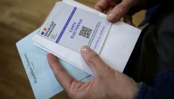 Une électrice attend pour déposer son bulletin de vote lors du 1er tour des législatives, le 30 juin 2024 à Toulouse, en Haute-Garonne