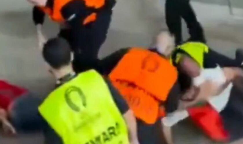 Stewards appeared to punch and kick a football fan
