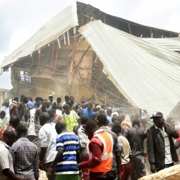 People and rescuers gather at the scene of a collapsed two-storey building in Jos, Nigeria. Pic: AP