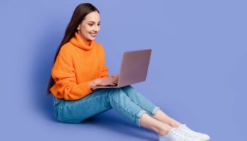 Amazon Prime Day 2024: Junge Frau mit MacBook auf dem Shoß