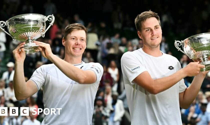 Harri Heliovaara and Henry Patten hold their Wimbledon doubles trophies