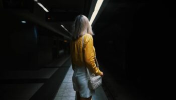 Eine Frau steht alleine im U-Bahn-Tunnel