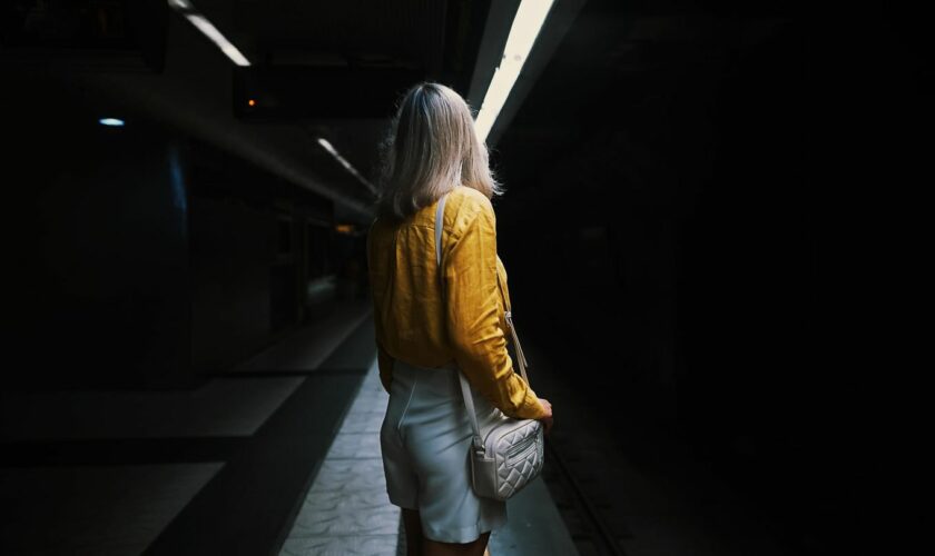 Eine Frau steht alleine im U-Bahn-Tunnel