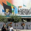Des Iraniennes marchent dans une rue de Téhéran devant une fresque murale où figurent le guide suprême iranien Ali Khamenei (G), et le fondateur de la République islamique d'Iran, l'ayatollah Khomeiny (D), le 6 juillet 2024 au lendemain de l'élection présidentielle