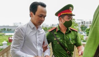 Trinh Van Quyet, a prominent Vietnamese business tycoon, is escorted to a court for his trial of defrauding stockholders, in Hanoi, Vietnam, July 22, 2024. (AP Photo/Anh Tuc)