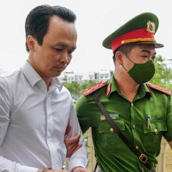 Trinh Van Quyet, a prominent Vietnamese business tycoon, is escorted to a court for his trial of defrauding stockholders, in Hanoi, Vietnam, July 22, 2024. (AP Photo/Anh Tuc)